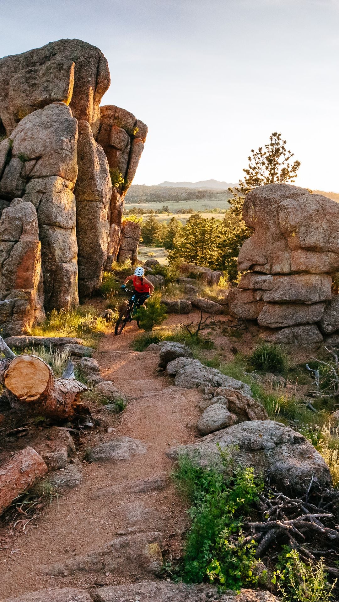 Mobile Version - Person biking on a trail through rocky landscape with large boulders