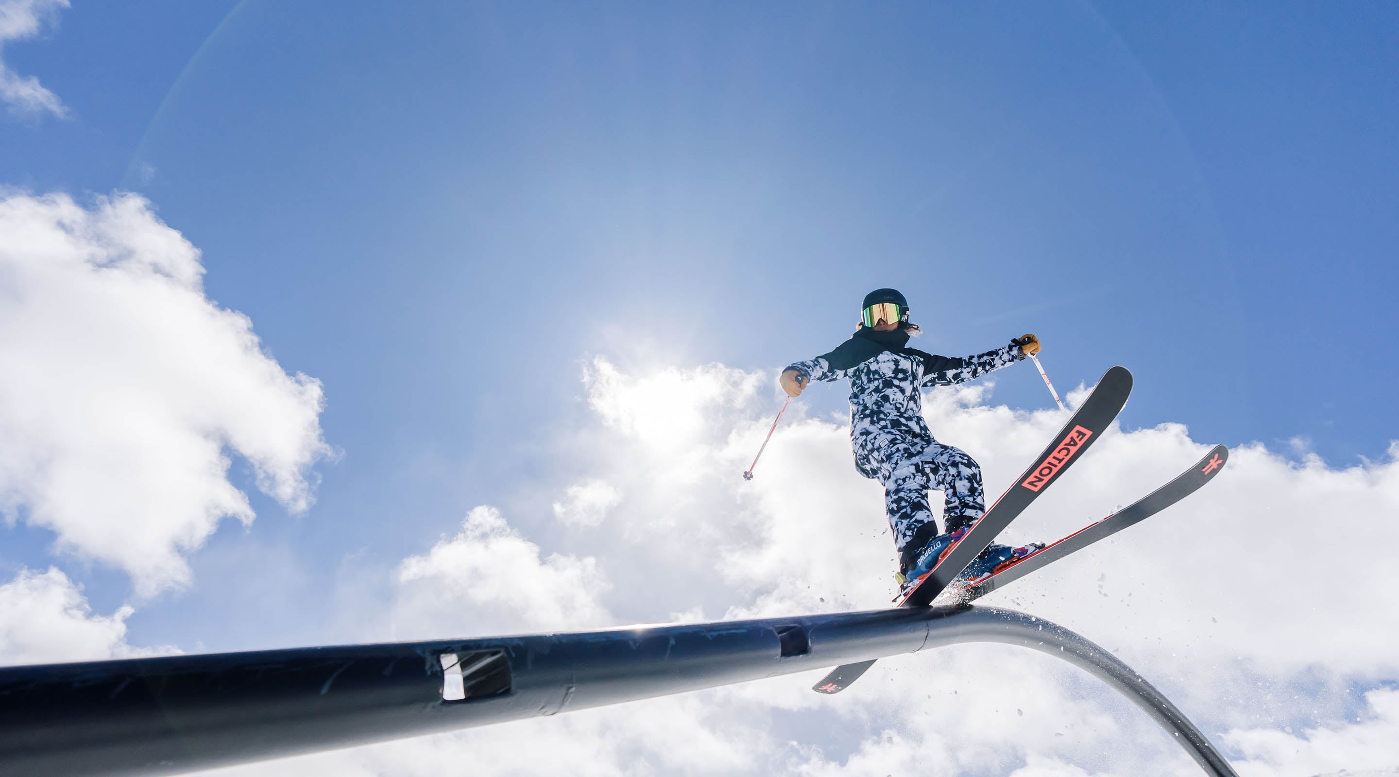 Women sliding down a rail on skis